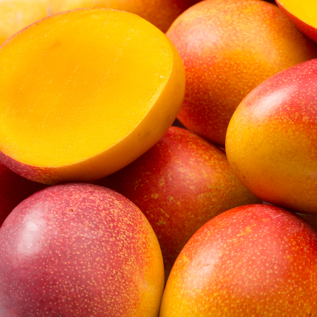 Südindische Mango – saftig, reif und nährstoffreich Mehrere reife, orangefarbene Mangofrüchte – eine halbiert mit sichtbarem Fruchtfleisch