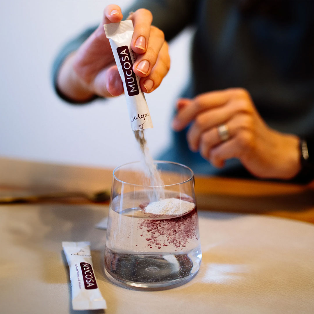 rubyni® MUCOSA – praktische Einnahme mit löslichem Pulver rubyni® MUCOSA Pulver wird aus einem Sachet in ein Glas Wasser gegeben. Im Wasser entstehen erste dunkelrote Schlieren – gut löslich, ideal zur täglichen Anwendung.