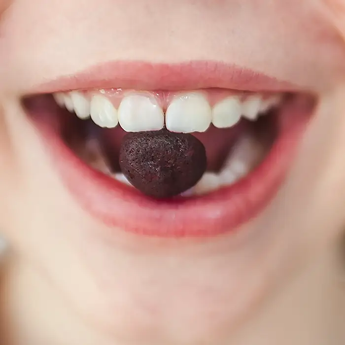 rubyni BITES Edelholunder - Abwehrkräfte und Immunsystem für Kinder stärken Kind mit rubyni® Bite zwischen den Zähnen