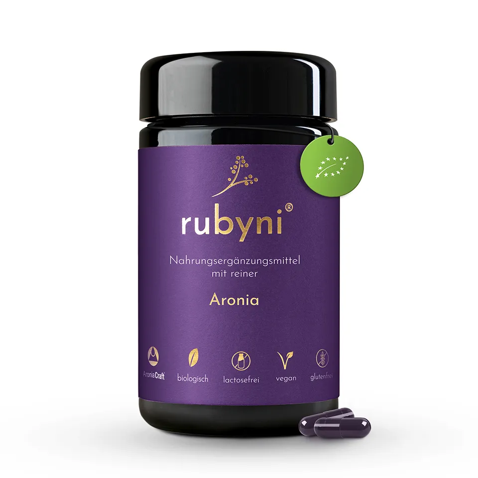 Nahrungsergänzungsmittel rubyni® Aronia im Glas mit violettem Etikett und Hinweis auf das verwendete Extrakt AroniaCraft
